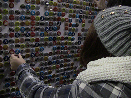 A student plucking from the wall a pin bearing Sheridan’s new ‘S’ logo. 