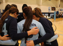 The women's volleyball team huddles 