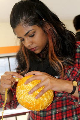Kumar wraps textured yarn around a styrofoam ball