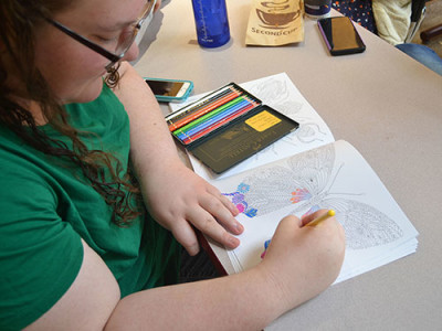 Nary Weis filling in a page from her colouring book. Photo by Olivia Little. 
