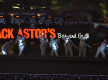 The performers dressed in white and holding lanterns entertain the crowd with their dance moves.