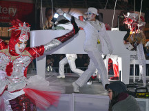 Performers in colourful costumes dance around on the stage in the middle of Yonge Dundas Square to start the night’s theatrical performance.