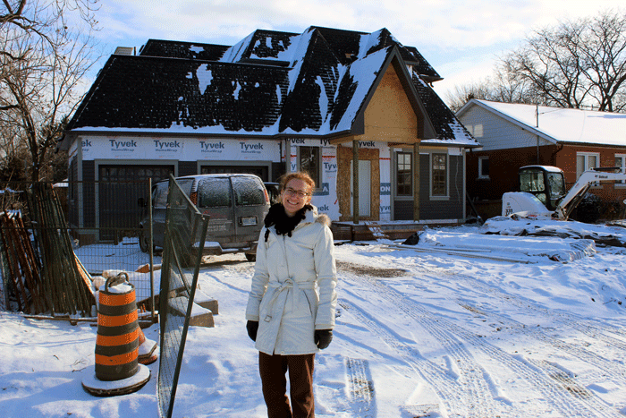 Standing in front of the new house under construction is Linda Morgan. 
